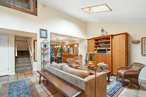 a dining hall with stainless steel appliances granite countertop a stove a sink a oven with a dining table and chairs