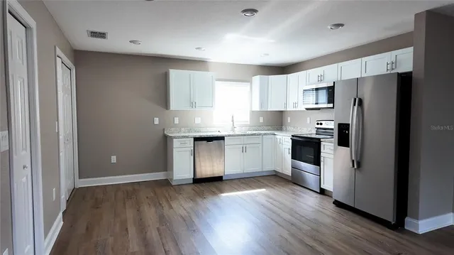 a kitchen with a refrigerator a sink and cabinets