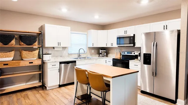a kitchen with a refrigerator a stove a microwave and cabinets
