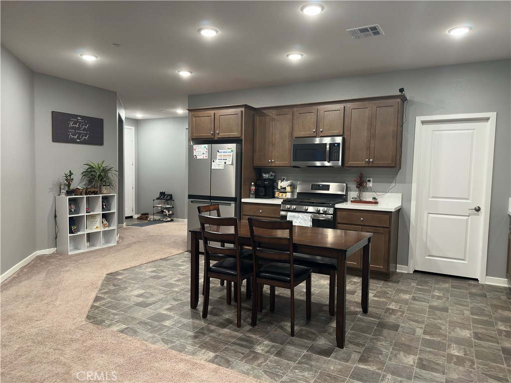 1351 Fiddleleaf Drive Banning, CA 92220 - Photo 3 of 16 a kitchen with kitchen island a dining table and appliances