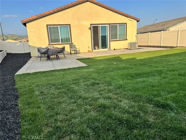 a backyard of a house with table and chairs