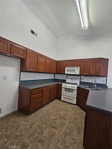 a kitchen with a sink a stove and cabinets