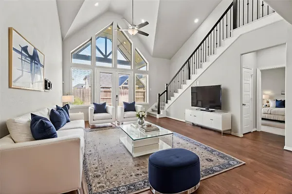 a living room with furniture a flat screen tv and a floor to ceiling window