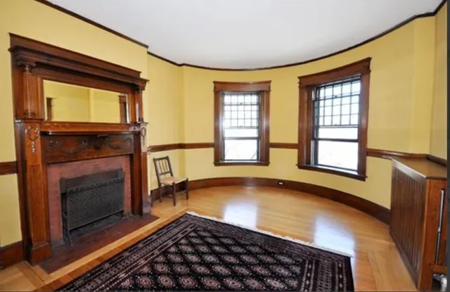 a view of an empty room with a fireplace and a window