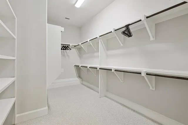 a view of walk in closet with empty racks