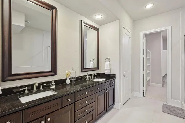 a bathroom with double sink and a mirror