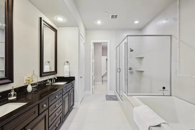 a bathroom with a granite countertop sink a mirror a bathtub and shower