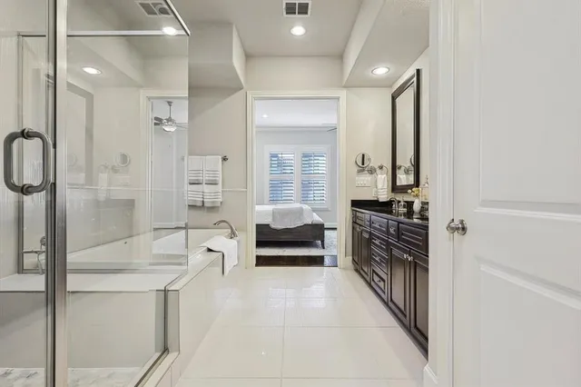 a en suite spacious bathroom with a double vanity sink a large mirror and a glass door shower