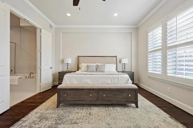a spacious bedroom with a bed and wooden floor