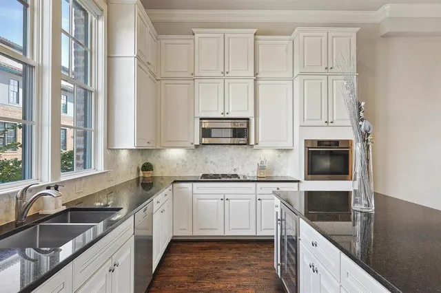 a kitchen with stainless steel appliances granite countertop a sink and a stove