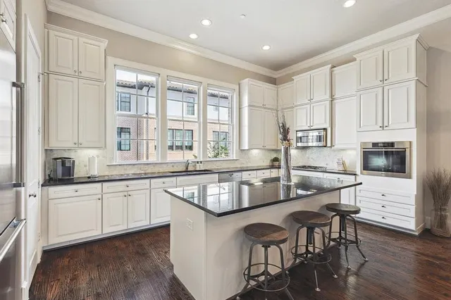 a kitchen with stainless steel appliances granite countertop a stove a sink and a refrigerator