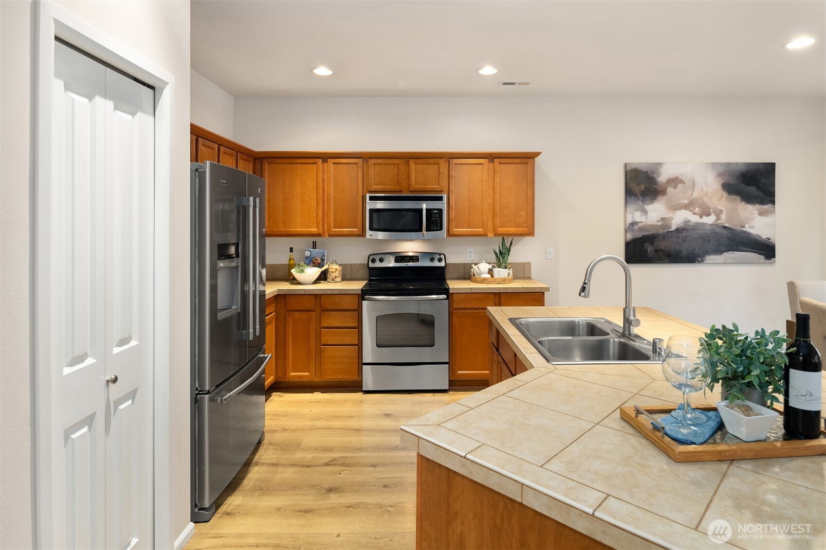 21272 Southeast 275th Court Maple Valley, WA 98038 - Photo 12 of 40 a kitchen with granite countertop a stove a sink and a refrigerator