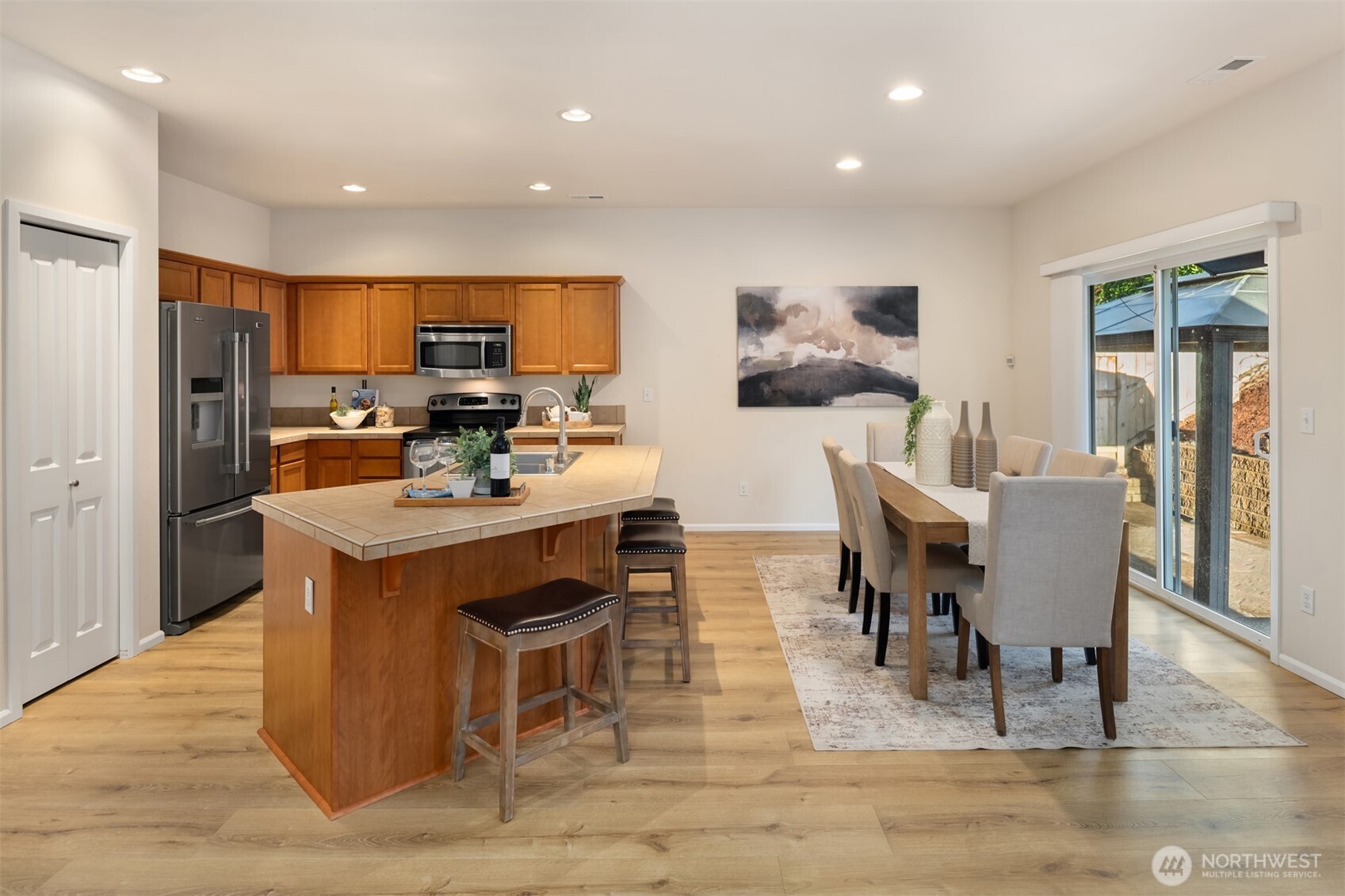 21272 Southeast 275th Court Maple Valley, WA 98038 - Photo 10 of 40 a living room with stainless steel appliances kitchen island granite countertop a dining table chairs and view of living room