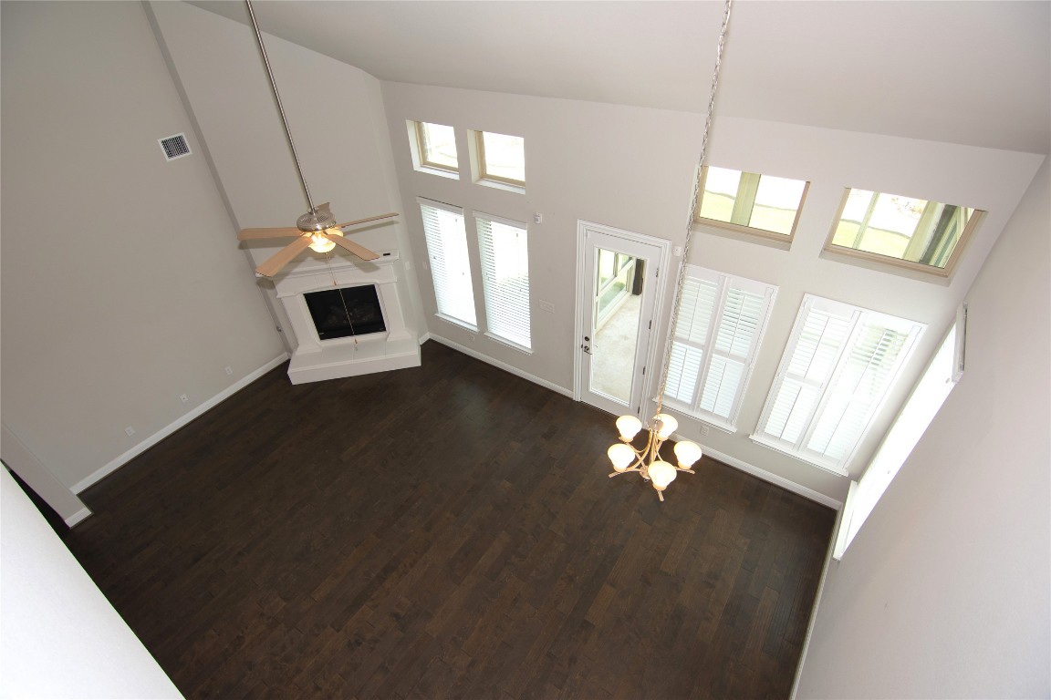3901 Rhythmic Drive Pflugerville, TX 78660 - Photo 20 of 40 a view of an empty room with chandelier fan and wooden floor
