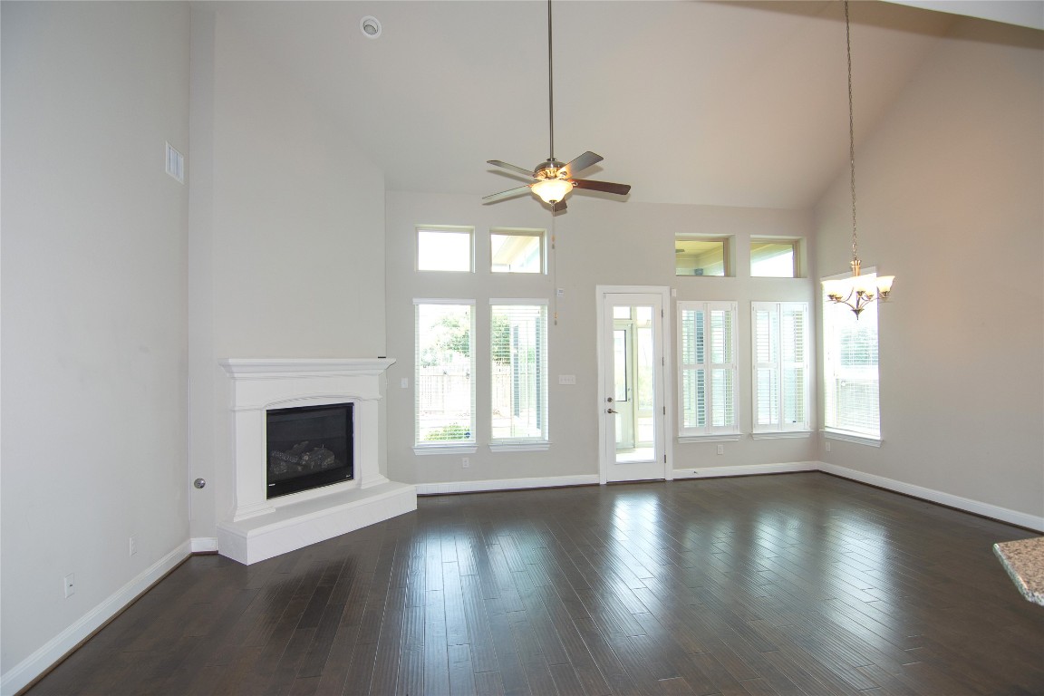 3901 Rhythmic Drive Pflugerville, TX 78660 - Photo 8 of 40 a view of an empty room with wooden floor fireplace and a window