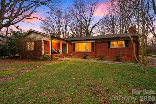 a front view of house with yard and trees around