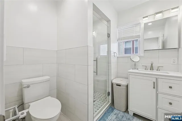 a bathroom with a toilet sink vanity and mirror