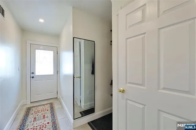 a view of hallway with closet and wooden floor