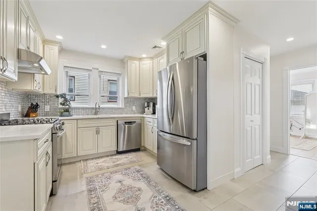a kitchen with a refrigerator sink and cabinets