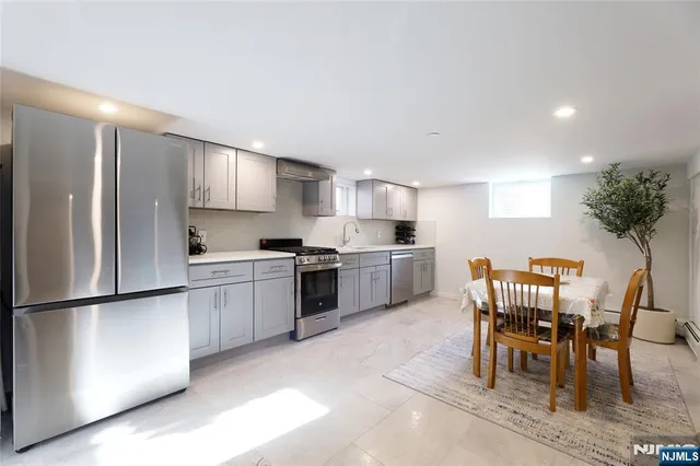 a kitchen with a refrigerator a table and chairs