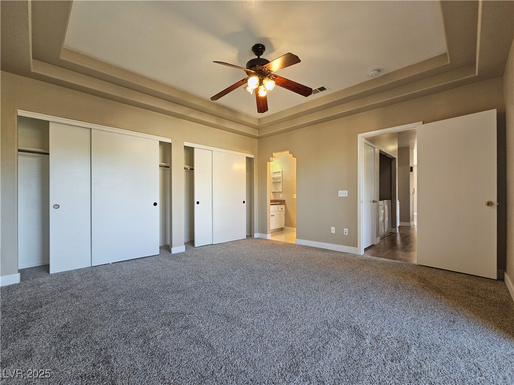1851 Hillpointe Road, Unit 2124 Henderson, NV 89074 - Photo 15 of 24 Unfurnished bedroom featuring a raised ceiling, multiple closets, and carpet floors
