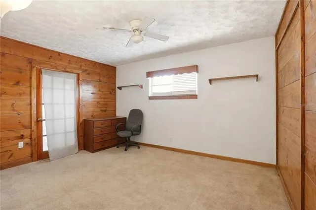a bedroom with a bed and a flat tv screen on dresser