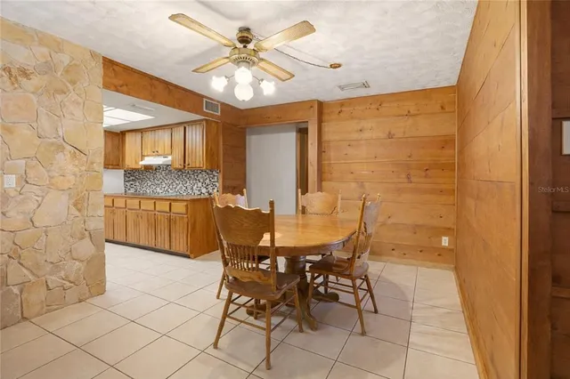 a view of a dining room with furniture and a chandelier fan