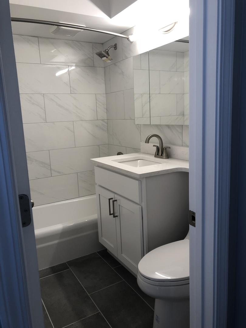 655 West Irving Park Road, Unit 1807 Chicago, IL 60613 - Photo 15 of 23 a bathroom with a sink toilet and shower
