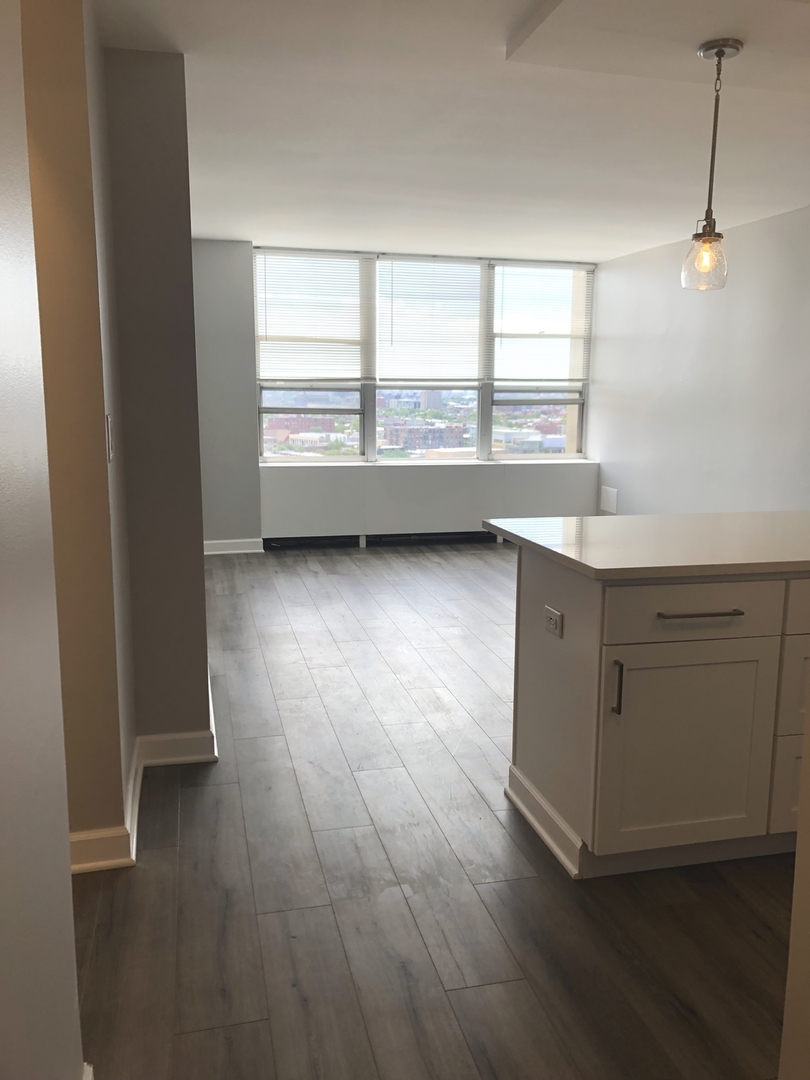 655 West Irving Park Road, Unit 1807 Chicago, IL 60613 - Photo 4 of 23 an empty room with wooden floor and windows