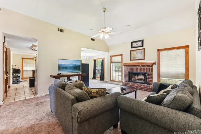 a living room with furniture a fireplace and a flat screen tv