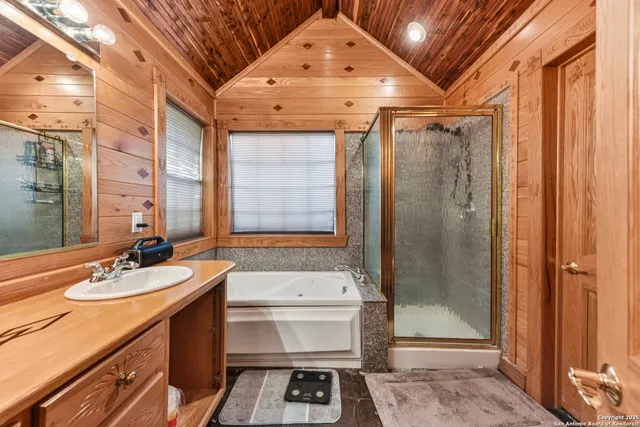 a bathroom with a sink a toilet a mirror and shower