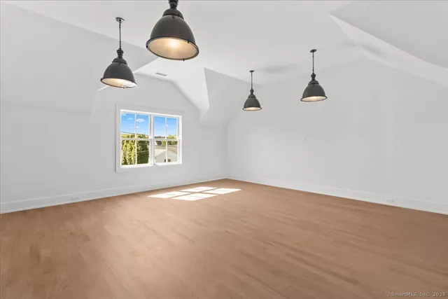 a view of an empty room with chandelier fan and a window