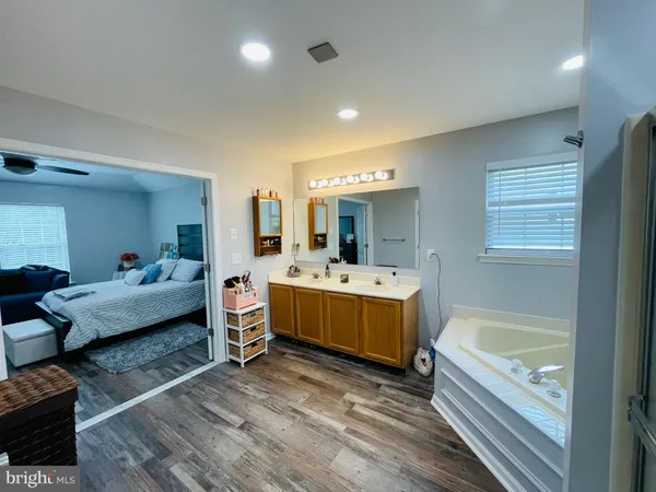 a bathroom with a tub double vanity sink and a mirror
