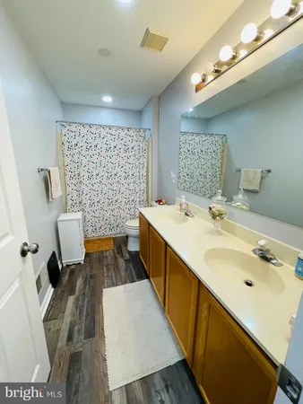 a spacious bathroom with a double vanity sink a mirror and shower