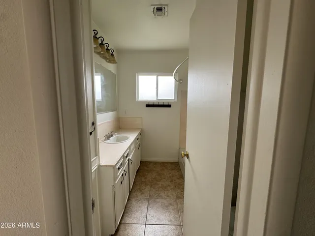a bathroom with a sink and mirror with toilet