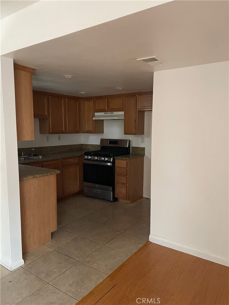 1315 Massachusetts Avenue, Unit 101 Riverside, CA 92507 - Photo 3 of 11 a kitchen with stainless steel appliances granite countertop a stove a sink and a refrigerator