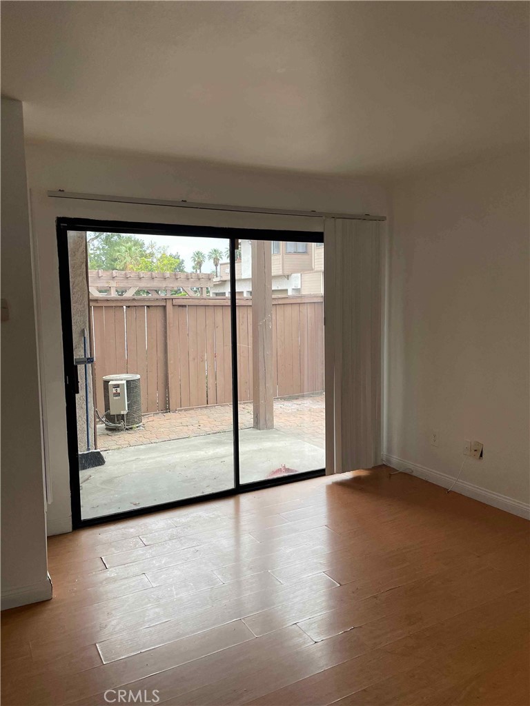 1315 Massachusetts Avenue, Unit 101 Riverside, CA 92507 - Photo 4 of 11 wooden floor in an empty room with a window