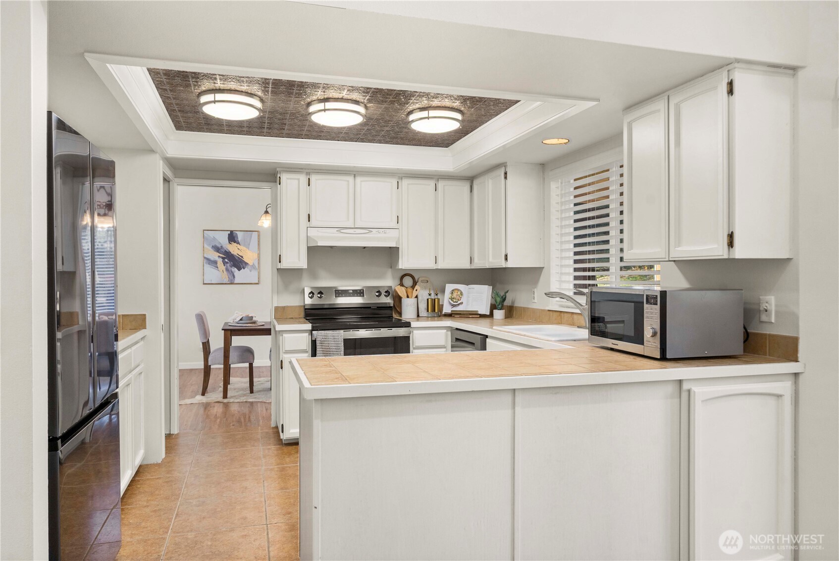 31611 37th Avenue Southwest Federal Way, WA 98023 - Photo 11 of 34 a kitchen with stainless steel appliances a sink a stove a refrigerator cabinets and a dining table