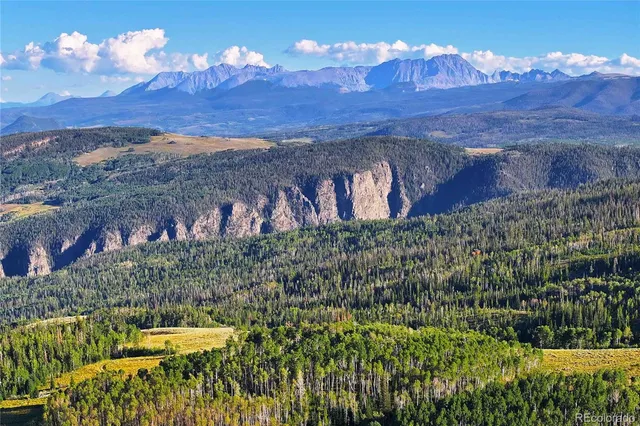 an aerial view of residential house with outdoor space and trees all around