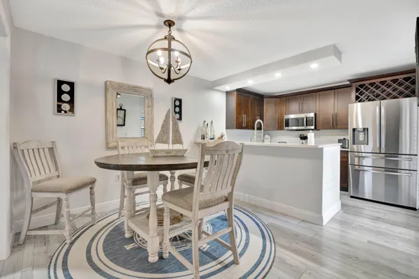 a view of a dining room with furniture a chandelier and wooden floor