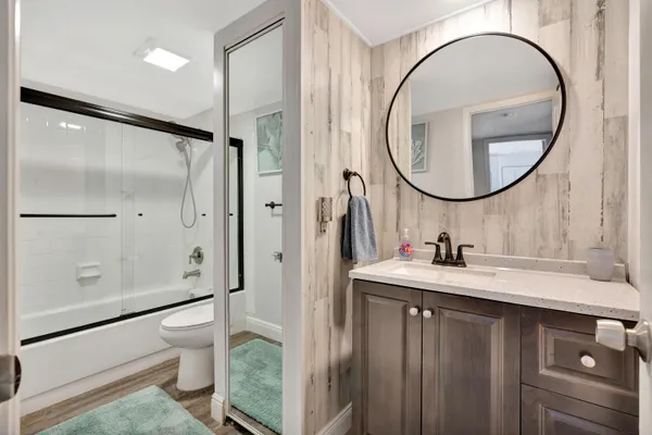a bathroom with a sink a toilet and a mirror