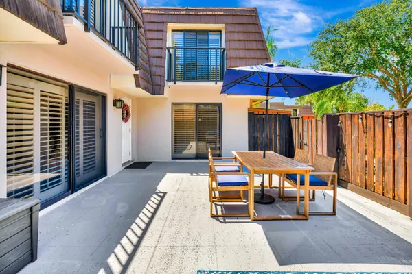 a view of a tables and chairs under an umbrella in the patio