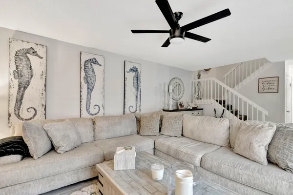 a living room with furniture and a ceiling fan