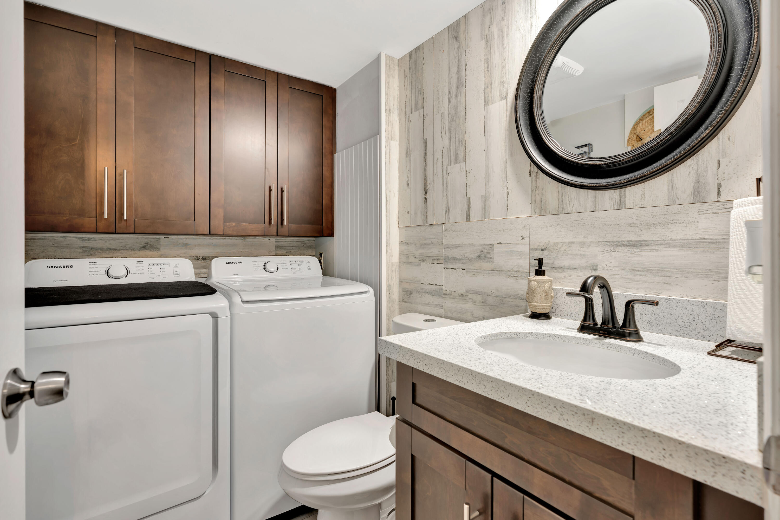 1209 12th Court Jupiter, FL 33477 - Photo 10 of 31 a bathroom with a granite countertop toilet sink and mirror