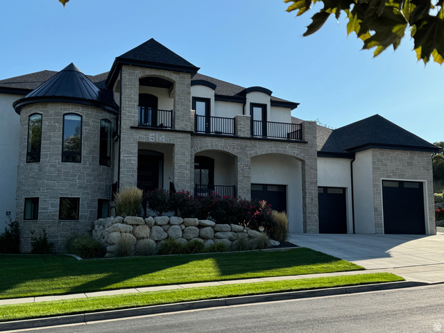 614 East High Lane Alpine, UT 84004 - Photo 1 of 75 French country home featuring stone siding, stucco siding, a balcony, concrete driveway, and a front yard