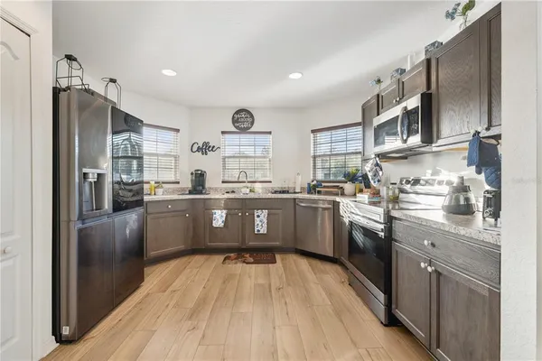 a large kitchen with stainless steel appliances lots of counter space and a sink