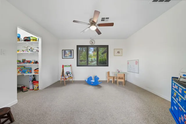 a view of room with toys and a ceiling fan