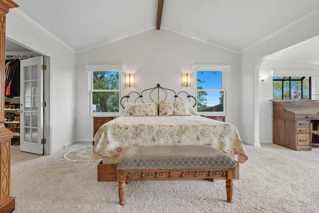 a bed sitting in a bedroom and table chair