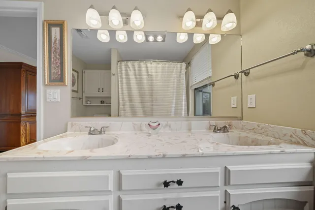 a bathroom with double vanity sinks a vanity and a mirror