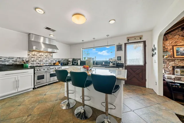 a kitchen with stainless steel appliances kitchen island granite countertop a stove a sink a counter top space and cabinets